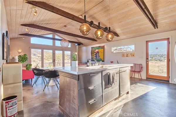 a view of a kitchen with stainless steel appliances granite countertop a stove and cabinets