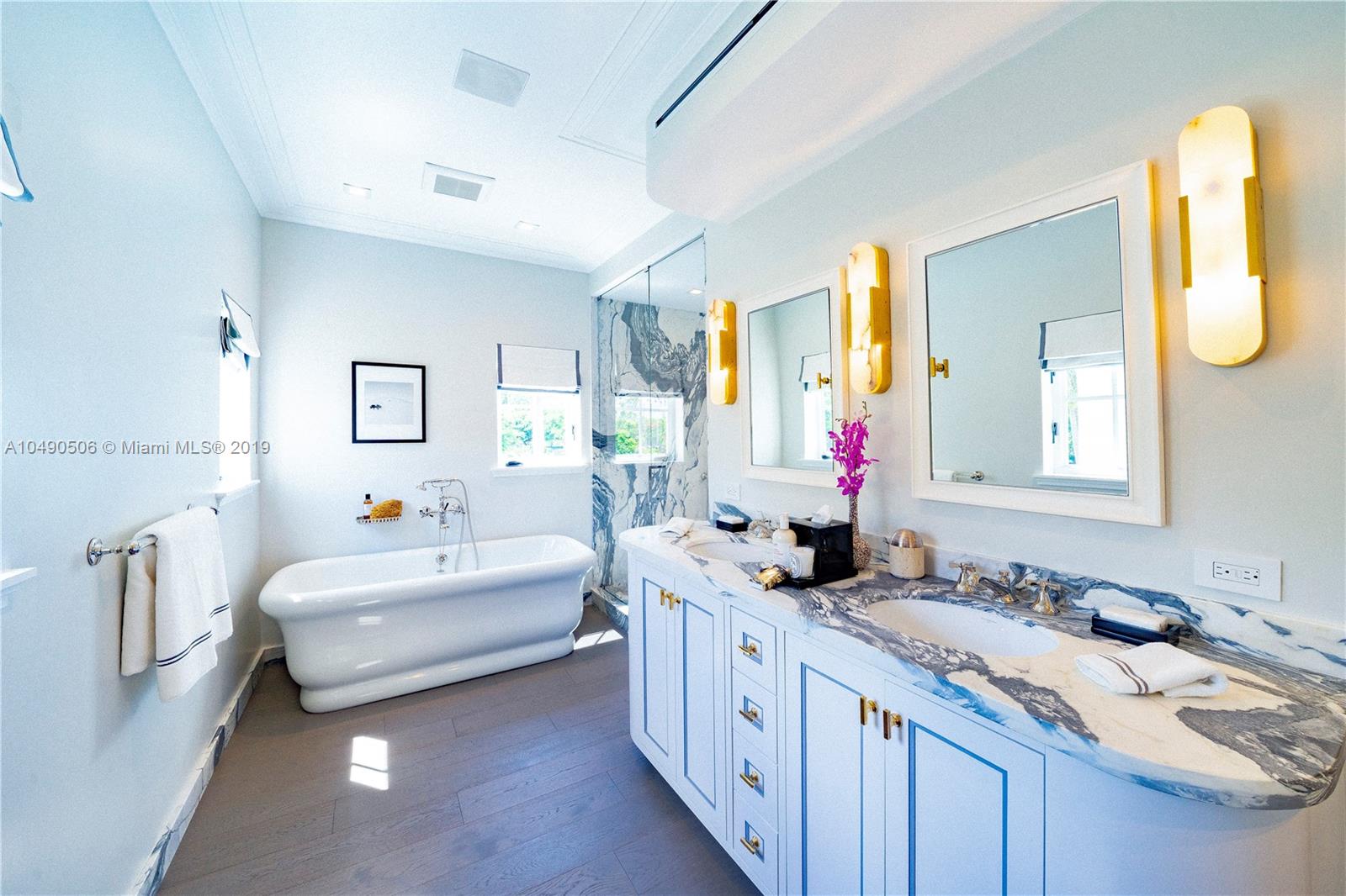 6332 Alton Road Miami Beach, FL 33141 - Photo 30 of 91 a bathroom with double vanity sinks a vanity tub and a mirror
