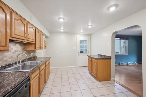a kitchen with a sink a stove top oven and cabinets