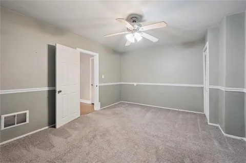 an empty room with closet and fan