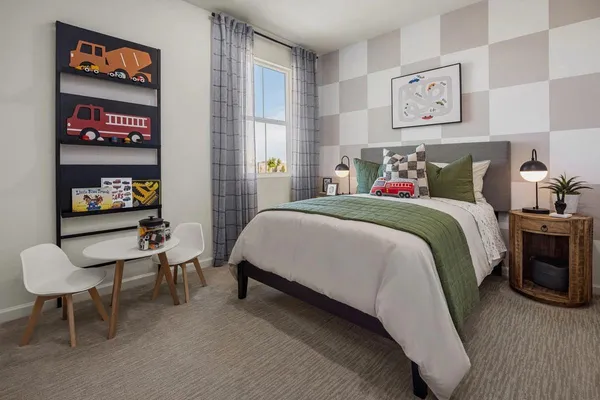 a bedroom with a bed a table and painting on the wall