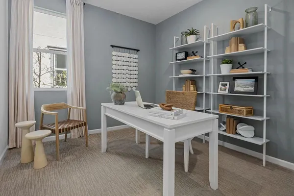 a view of a workspace with furniture and a bookshelf