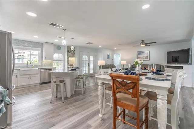 a dining room with stainless steel appliances kitchen island granite countertop a dining table chairs and view living room