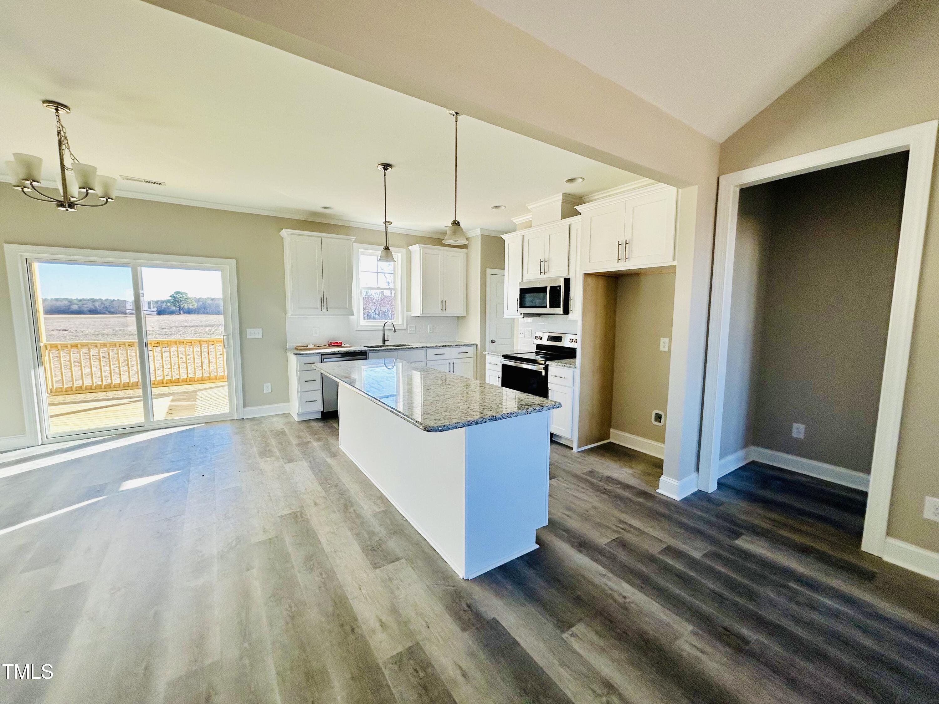 9787 Pace Road Bailey, NC 27807 - Photo 6 of 18 a large kitchen with kitchen island a large window a refrigerator a sink and white cabinets