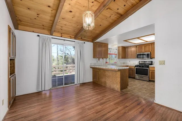a large kitchen with a large window stainless steel appliances and wooden floor