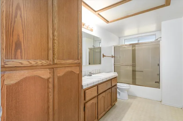 a bathroom with a sink a toilet and shower