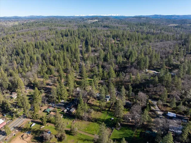 an aerial view of a houses with a lush green hillside