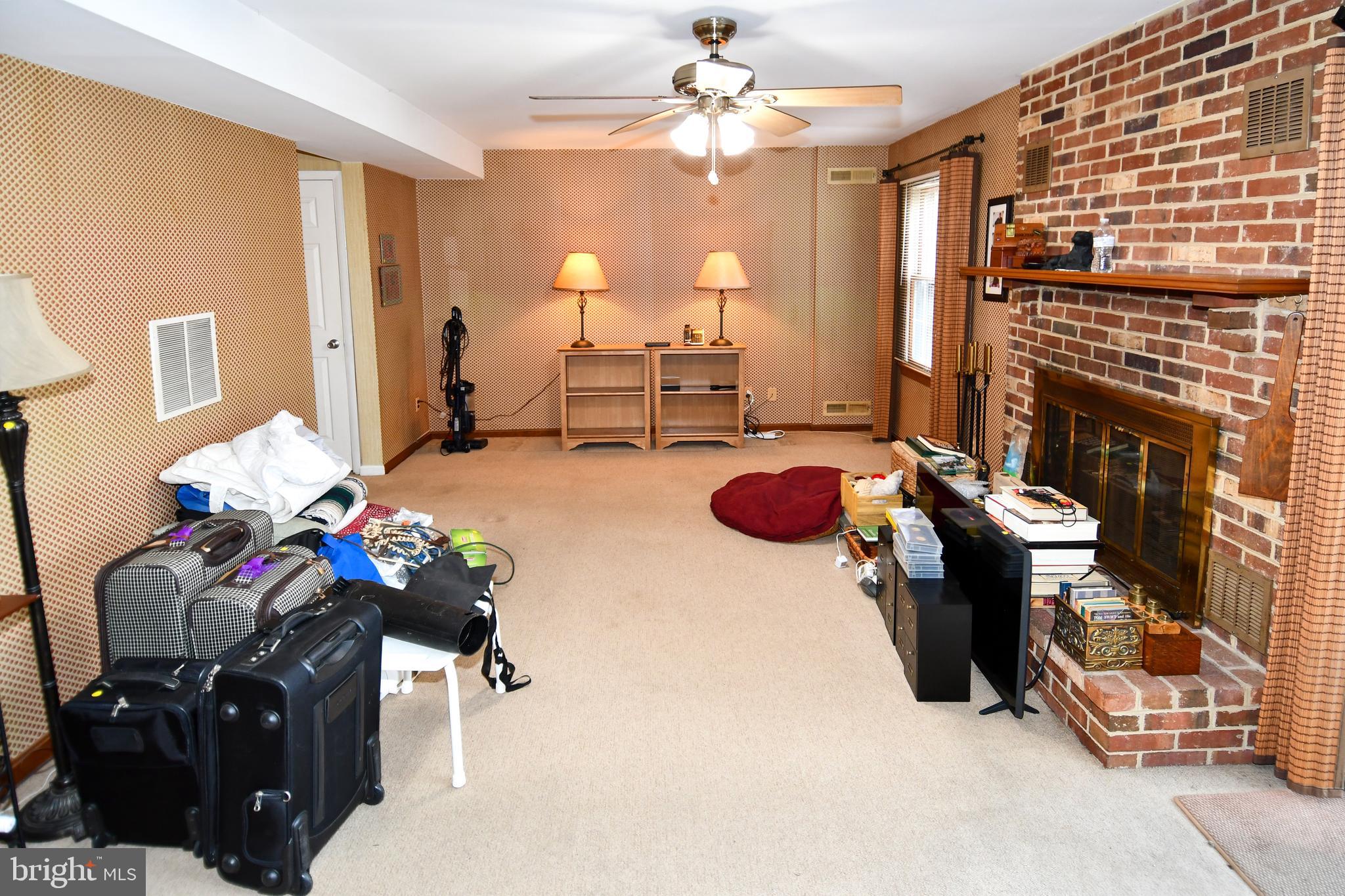 61 Oak Shade Road Gaithersburg, MD 20878 - Photo 26 of 42 a living room with furniture a chandelier and a fireplace