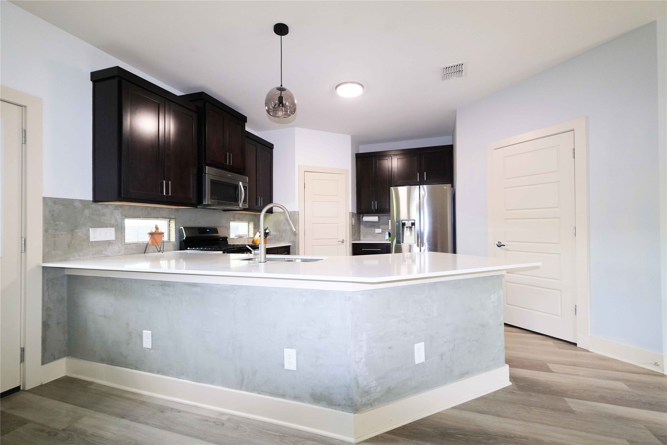 604 Allen Street, Unit 104 Austin, TX 78702 - Photo 5 of 16 a large kitchen with stainless steel appliances a large counter top cabinets and wooden floor