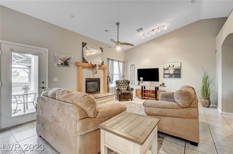 987 Cutter Street Henderson, NV 89011 - Photo 8 of 17 A comforting living space features a tiled fireplace and soaring vaulted ceilings, perfect for relaxation.