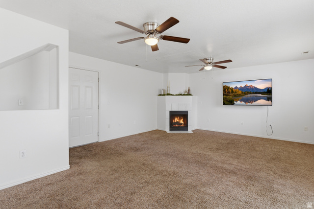 134 West 475 South Ogden, UT 84404 - Photo 10 of 27 Unfurnished living room featuring a ceiling fan, a fireplace, and carpet floors