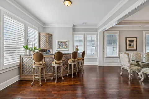 a kitchen with stainless steel appliances granite countertop a table chairs stove and white cabinets
