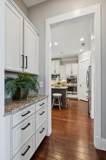 a kitchen with stainless steel appliances granite countertop a sink a stove and a white cabinets