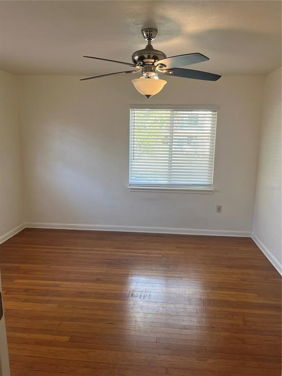 1485 Cleveland Street Clearwater, FL 33755 - Photo 9 of 14 an empty room with wooden floor fan and windows