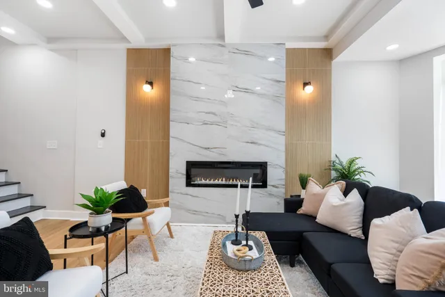 a living room with furniture a fireplace and a window