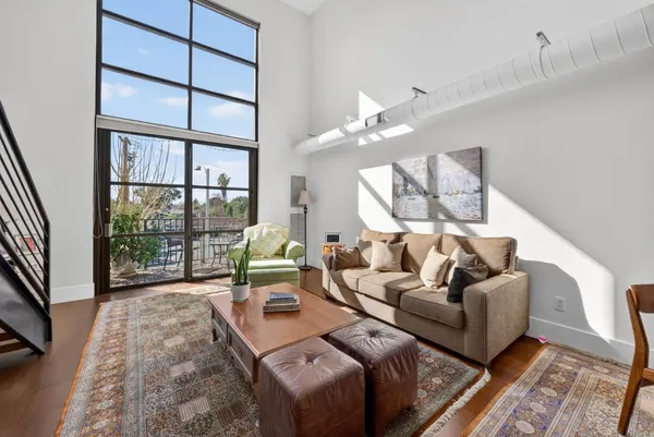 a living room with furniture fireplace and a large window