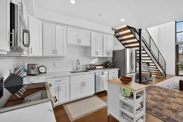 a kitchen with stainless steel appliances kitchen island granite countertop a stove and a sink