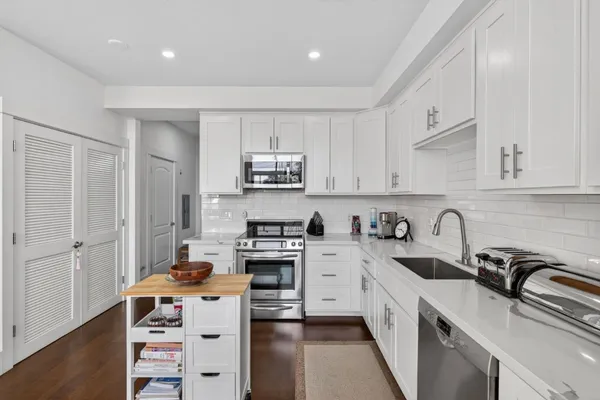 a kitchen with stainless steel appliances a sink stove and cabinets