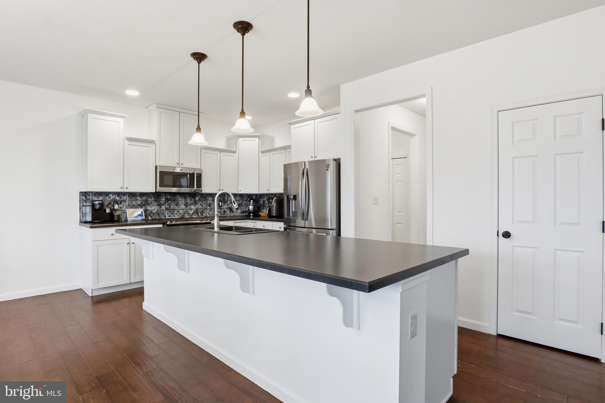 215 Azalea Drive Windsor, PA 17366 - Photo 14 of 68 a kitchen with stainless steel appliances granite countertop a sink a refrigerator a stove a kitchen island with wooden floor
