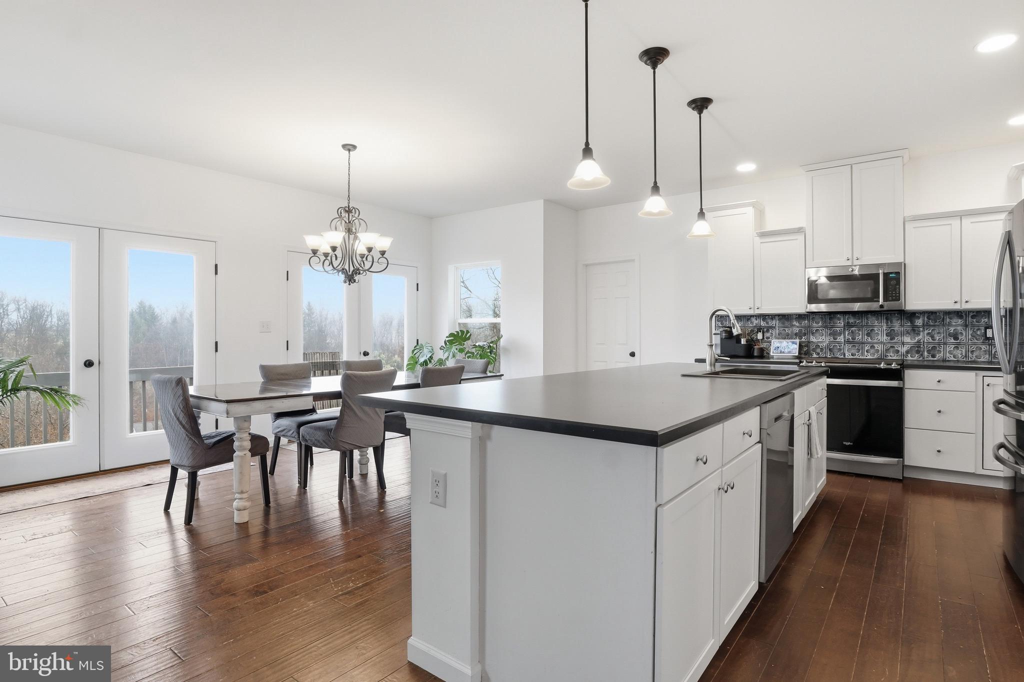 215 Azalea Drive Windsor, PA 17366 - Photo 18 of 68 a kitchen with stainless steel appliances granite countertop a stove a sink a kitchen island with wooden floor and cabinets