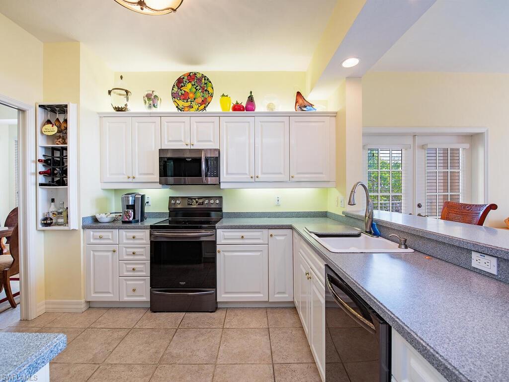 451 Bayfront Place, Unit 5311 Naples, FL 34102 - Photo 6 of 22 a kitchen with stainless steel appliances a stove microwave and cabinets