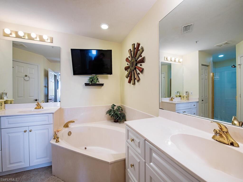 451 Bayfront Place, Unit 5311 Naples, FL 34102 - Photo 8 of 22 a bathroom with a tub a sink and mirror