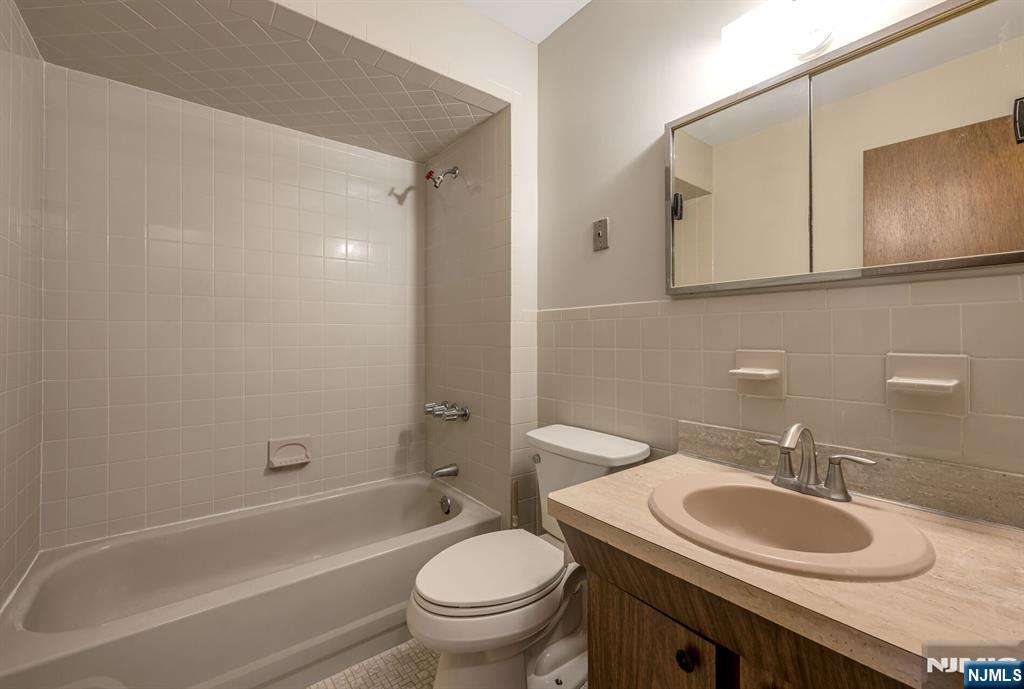 415 Goffle Road Wyckoff, NJ 07481 - Photo 19 of 30 a bathroom with a granite countertop toilet sink and mirror