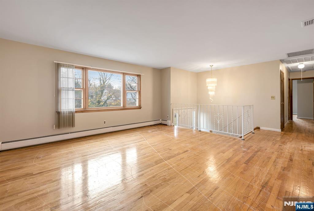 415 Goffle Road Wyckoff, NJ 07481 - Photo 6 of 30 a view of an empty room with a window and wooden floor