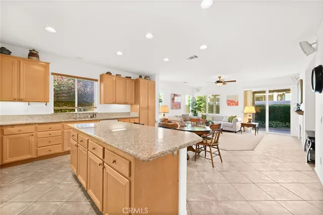 a living room with stainless steel appliances granite countertop furniture and a kitchen view