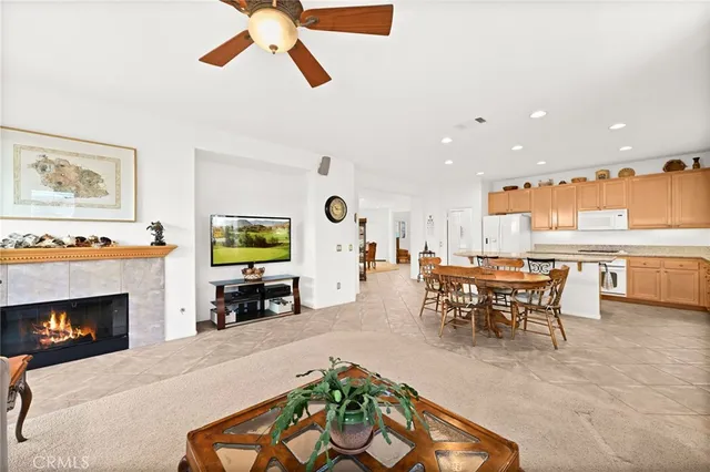 a kitchen with granite countertop a refrigerator a stove a sink dishwasher and white cabinets with wooden floor