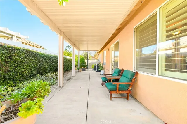 a porch with a table and chairs and potted plants