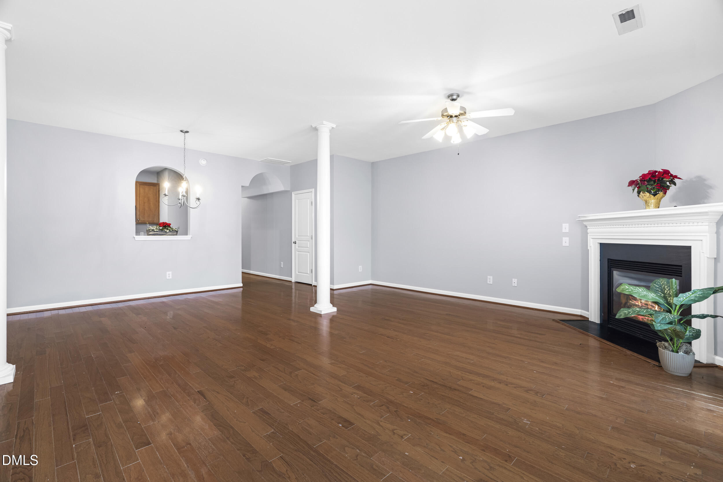 2636 Asher View Court Raleigh, NC 27606 - Photo 9 of 35 an empty room with wooden floor chandelier fan and windows