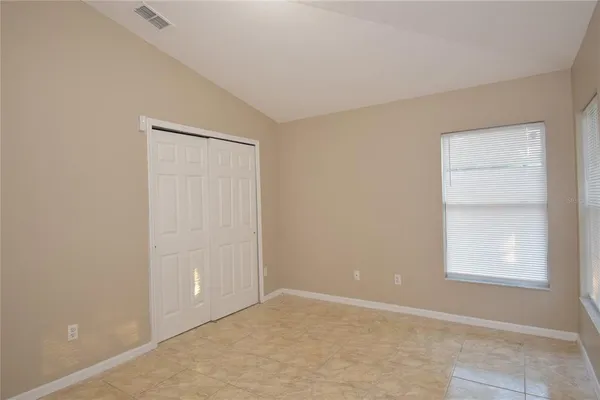 an empty room with windows and closet