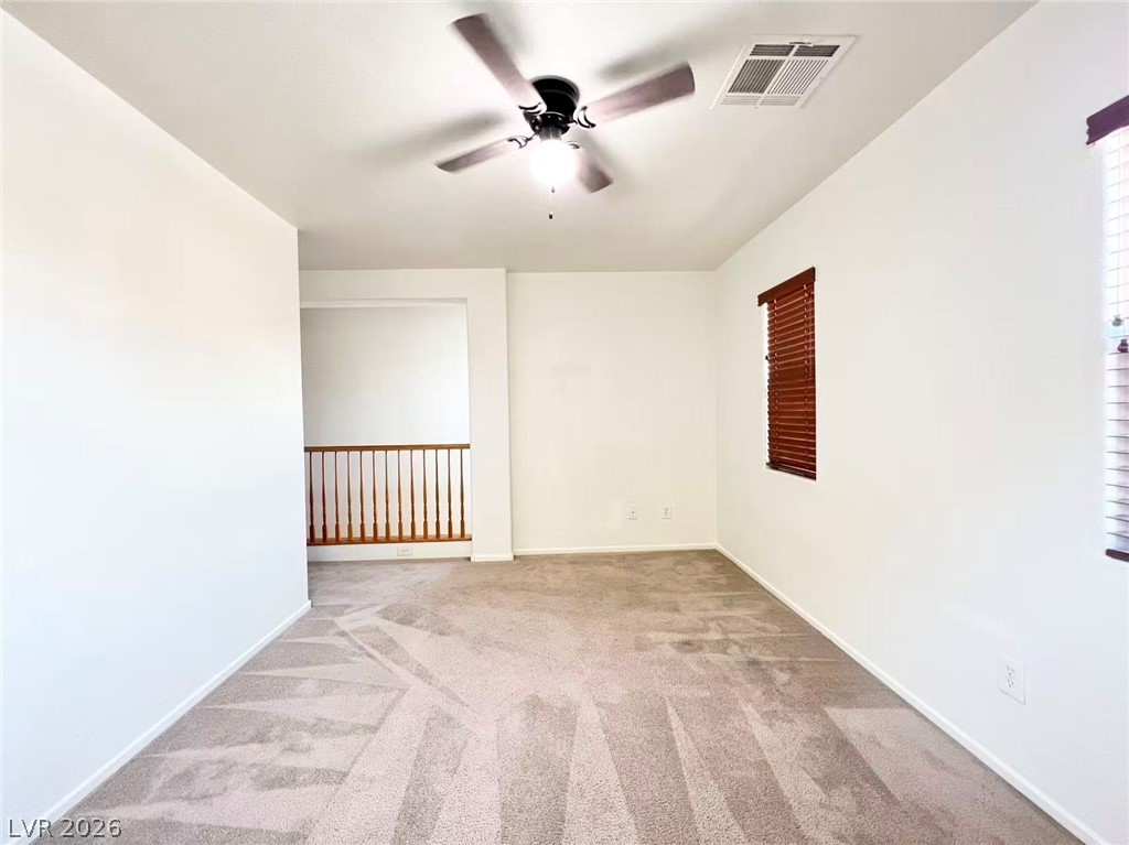 11143 Ranch Valley Street Las Vegas, NV 89179 - Photo 11 of 23 A versatile open space with soft carpeting and a ceiling fan, ready for personalization.