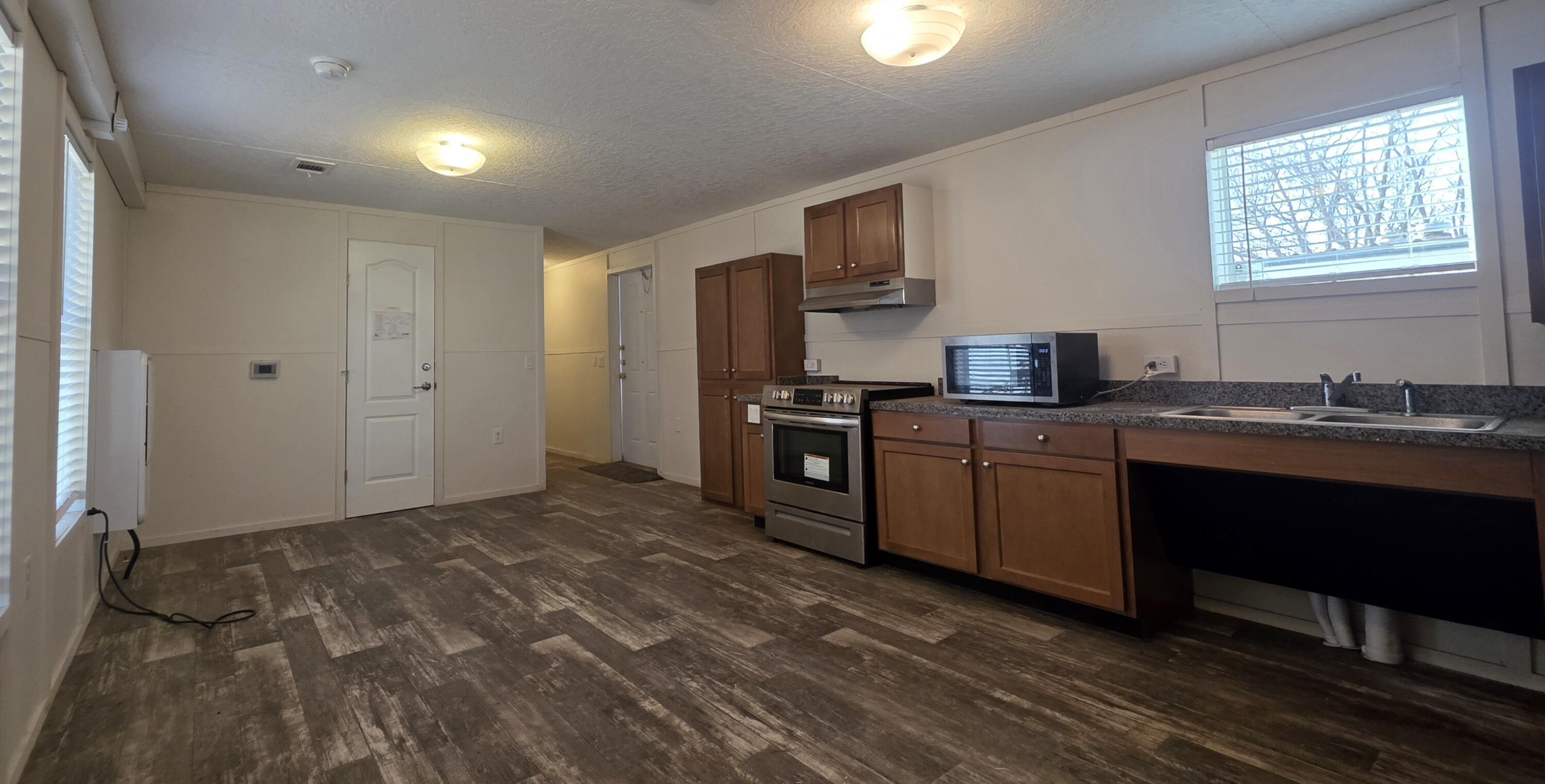 6801 19th Street, Unit 179 Lubbock, TX 79407 - Photo 3 of 15 a kitchen with granite countertop a sink cabinets and stainless steel appliances
