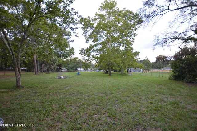 a view of a green field with trees
