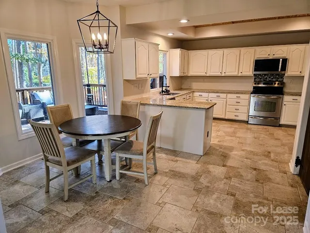 a kitchen with a dining table chairs and refrigerator