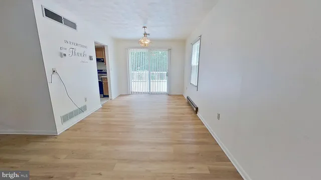a view of a hallway with wooden floor and entryway