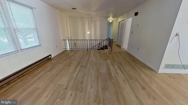 a view of a room with wooden floor and windows