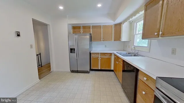 a kitchen with a sink a refrigerator and cabinets