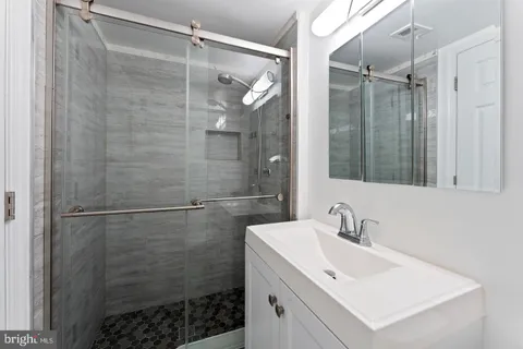 a bathroom with a shower sink and mirror