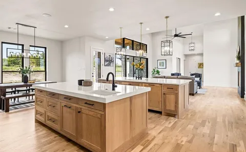a large kitchen with stainless steel appliances a lot of counter space and a wooden floor