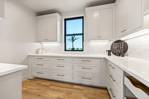 a kitchen with granite countertop white cabinets and white stainless steel appliances