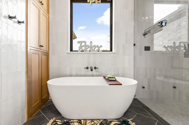 a white bath tub sitting next to a bathroom sink