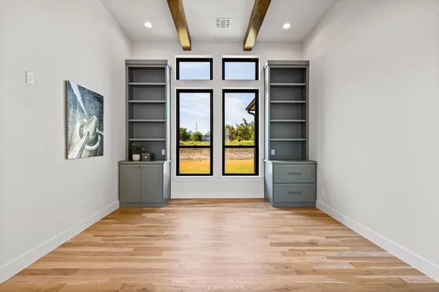an empty room with window and ceiling fan