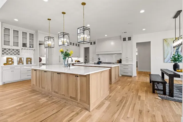 a large kitchen with stainless steel appliances kitchen island granite countertop a sink and cabinets