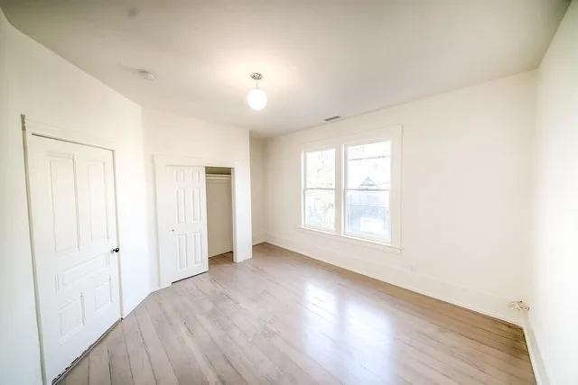 a view of a livingroom with wooden floor and a window