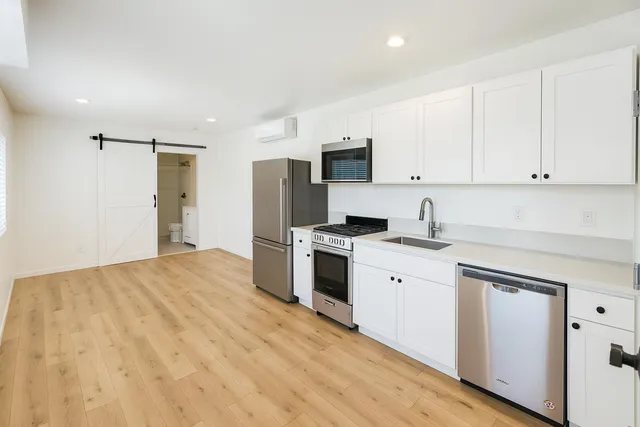 a kitchen with white cabinets and stainless steel appliances