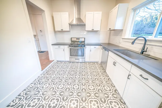 a kitchen with a sink a stove a refrigerator and a window