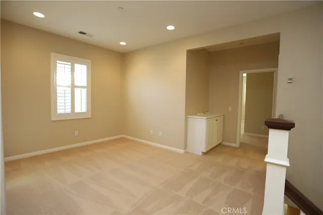an empty room with a window and wooden floor